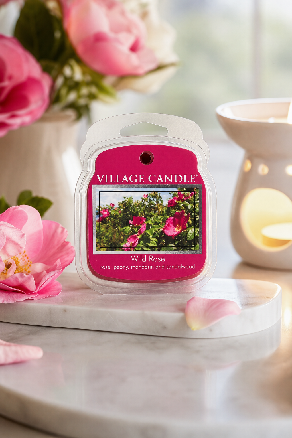 Village Candle Wild Rose Verpackung auf einer Ablage neben einer Duftlampe