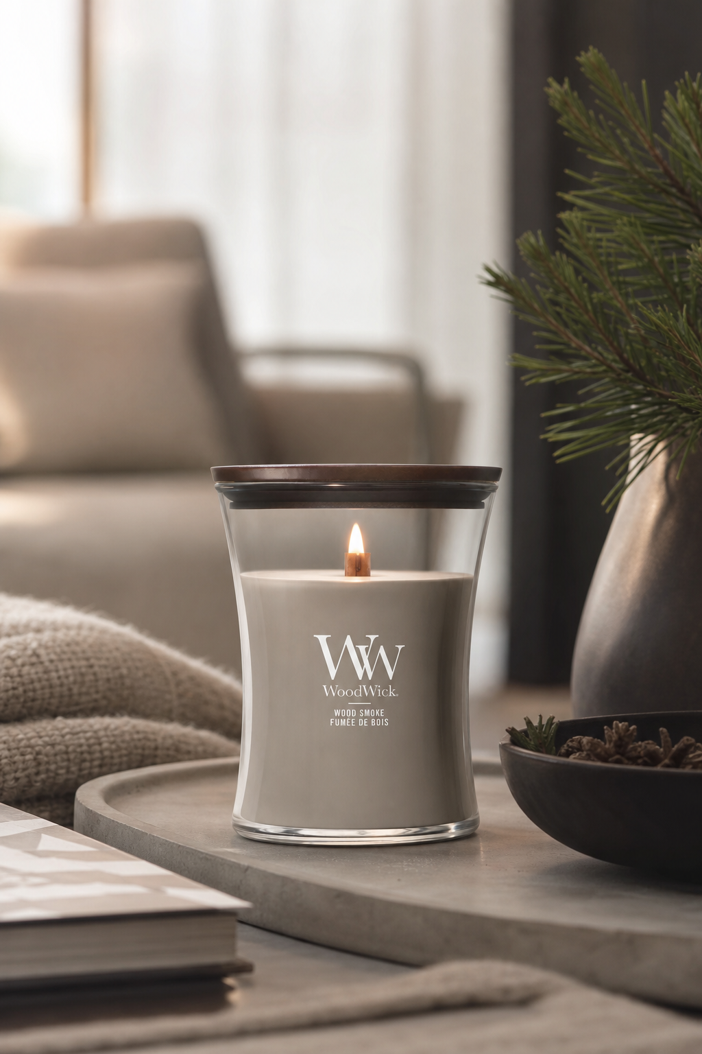 WoodWick Wood Smoke Kerze mit brennender Flamme auf einem Tisch