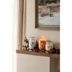 Yankee Candle Woodland Weekend Memories Kerze neben zwei weiteren Duftkerzen auf einem Regal