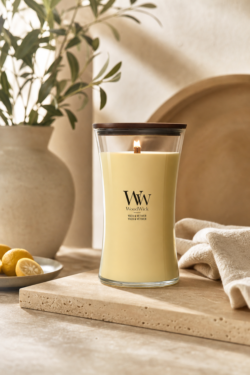Brennende WoodWick Yuzu & Vetiver Kerze auf einer Ablage im Wohnraum