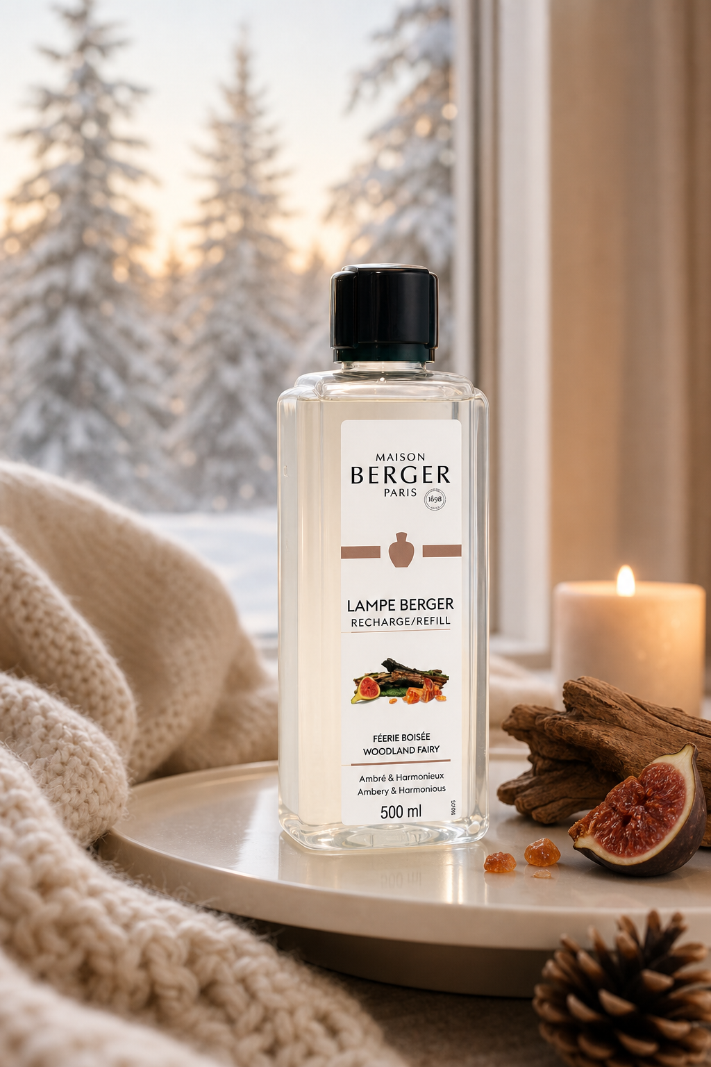 Maison Berger Nachfüllflasche steht auf einem Tisch vor verschneiten Tannen und einer Kerze